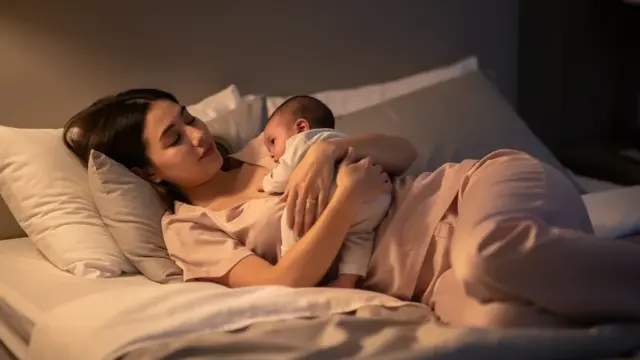 Stillen im Bett: entspannte Seitenlage mit Neugeborenem und Stillkissen für Komfort