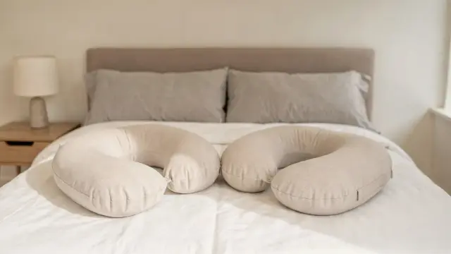 U-Kissen und C-Kissen auf einem Bett als Vergleich für die Schwangerschaft