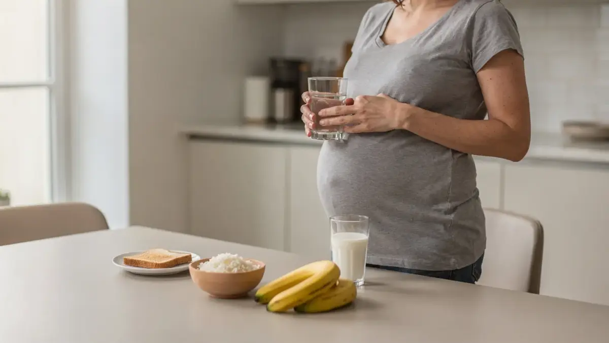 Schwangere Frau in der Küche mit Wasser und leichten Speisen zum Thema Sodbrennen in der Schwangerschaft